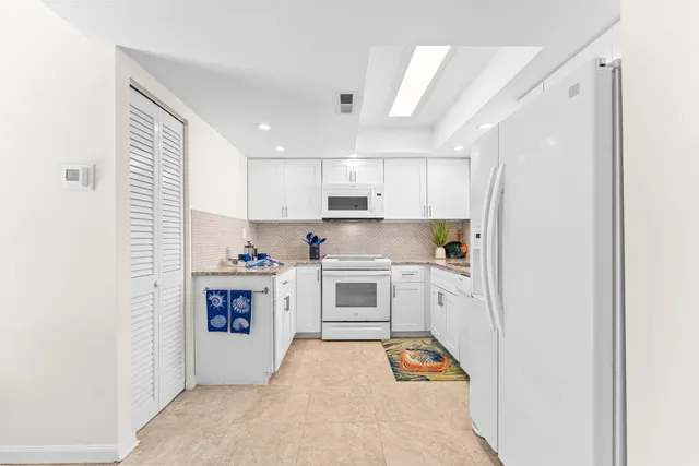 a kitchen with stainless steel appliances white cabinets and a refrigerator