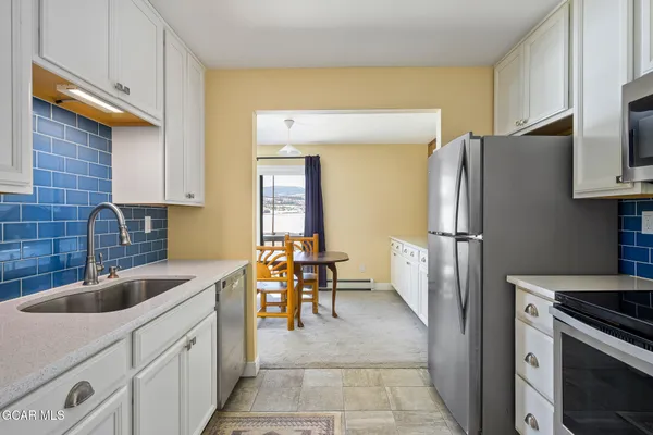a kitchen with stainless steel appliances granite countertop a refrigerator and a sink