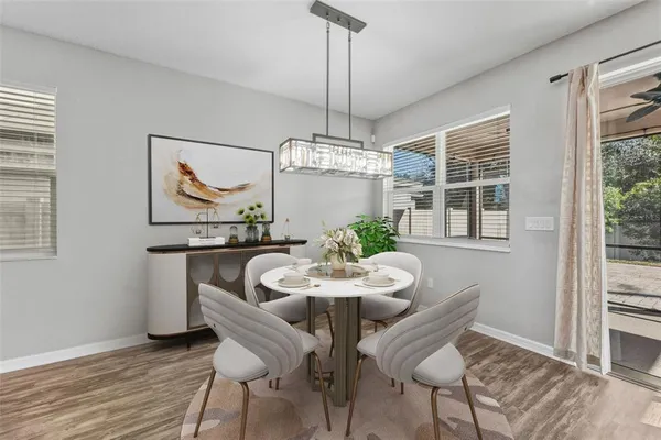 a dining room with furniture a chandelier and wooden floor