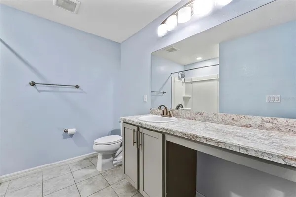 a bathroom with a granite countertop sink a toilet and a mirror
