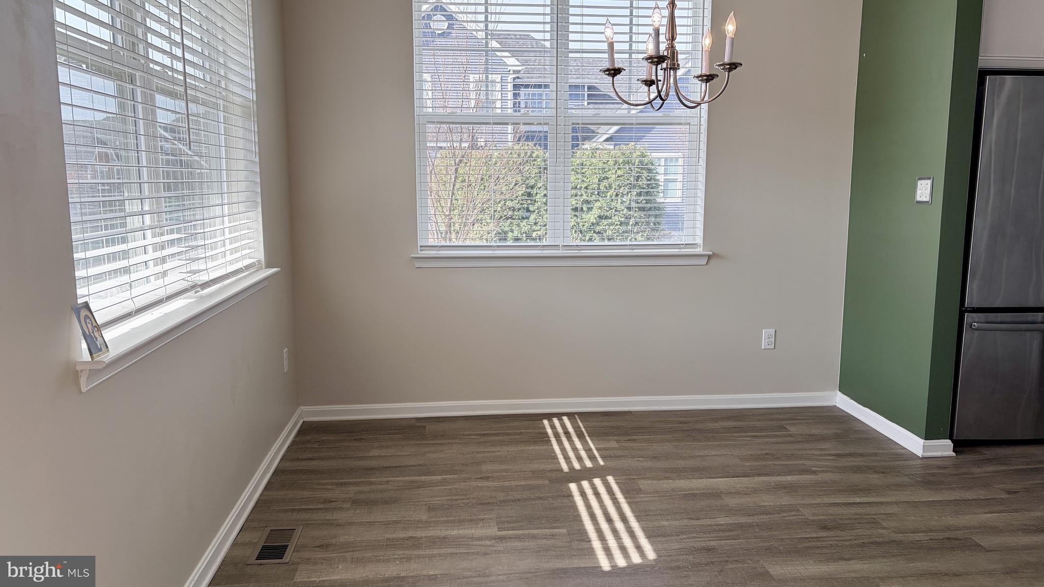 301 Arch Street Milton, DE 19968 - Photo 9 of 34 an empty room with wooden floor and windows