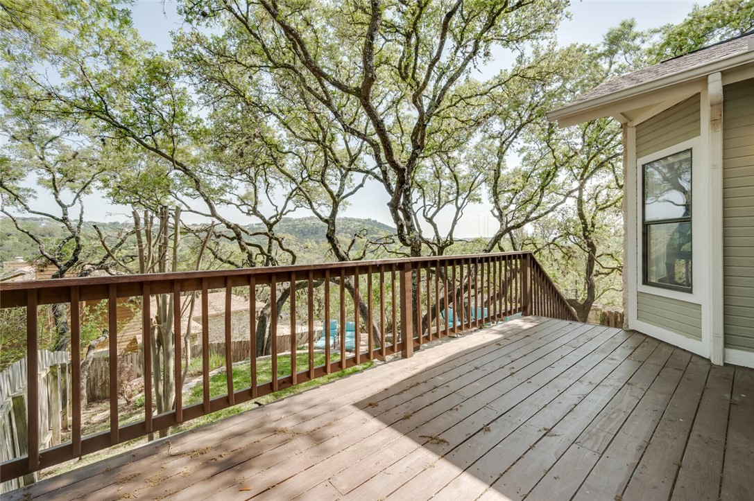 a balcony with wooden floor and trees