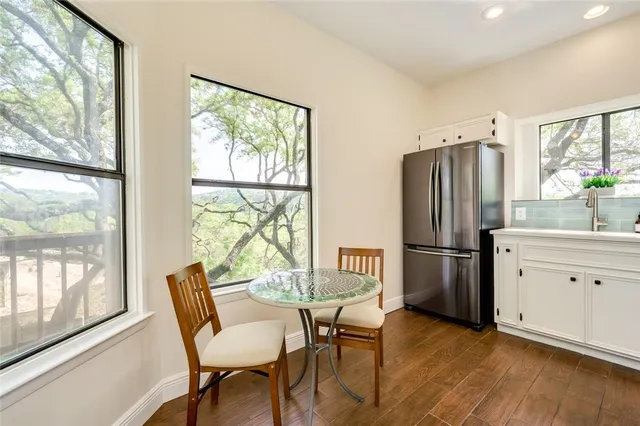 a kitchen with stainless steel appliances a refrigerator a table and chairs
