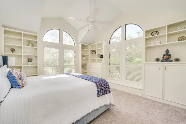 a spacious bedroom with a bed a table and large window