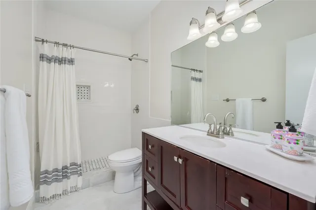 a bathroom with a double vanity sink mirror and toilet