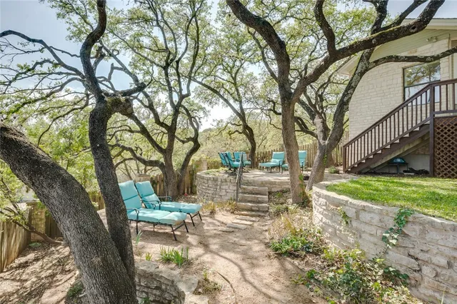 a view of a yard with table and chairs and a large tree