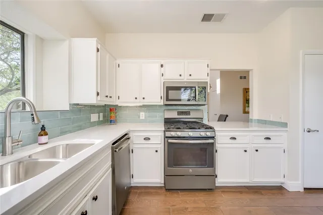 a kitchen with white cabinets and white appliances