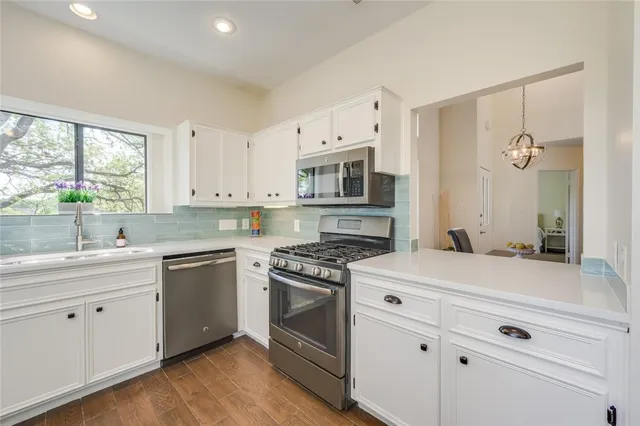 a kitchen with white cabinets and appliances