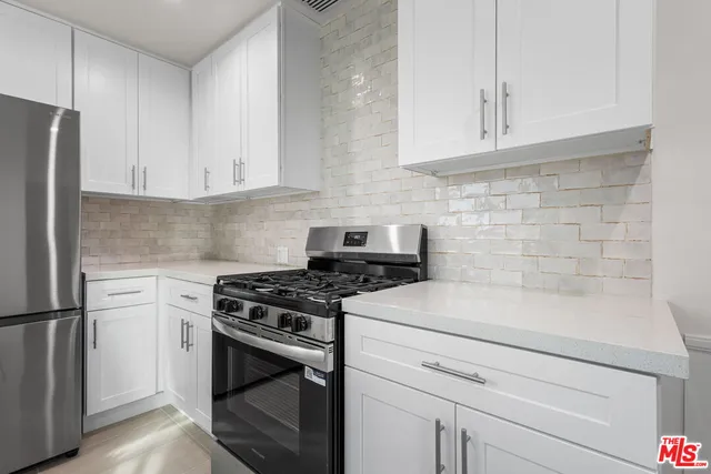 a kitchen with granite countertop white cabinets and white appliances