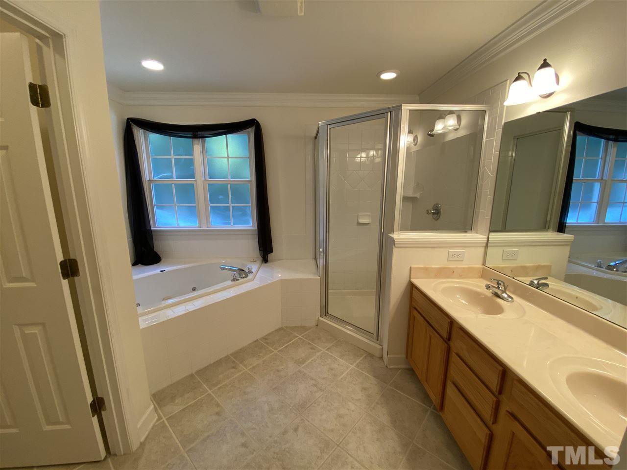 4606 Mistiflower Drive Raleigh, NC 27606 - Photo 6 of 9 a bathroom with a tub sink shower and mirror