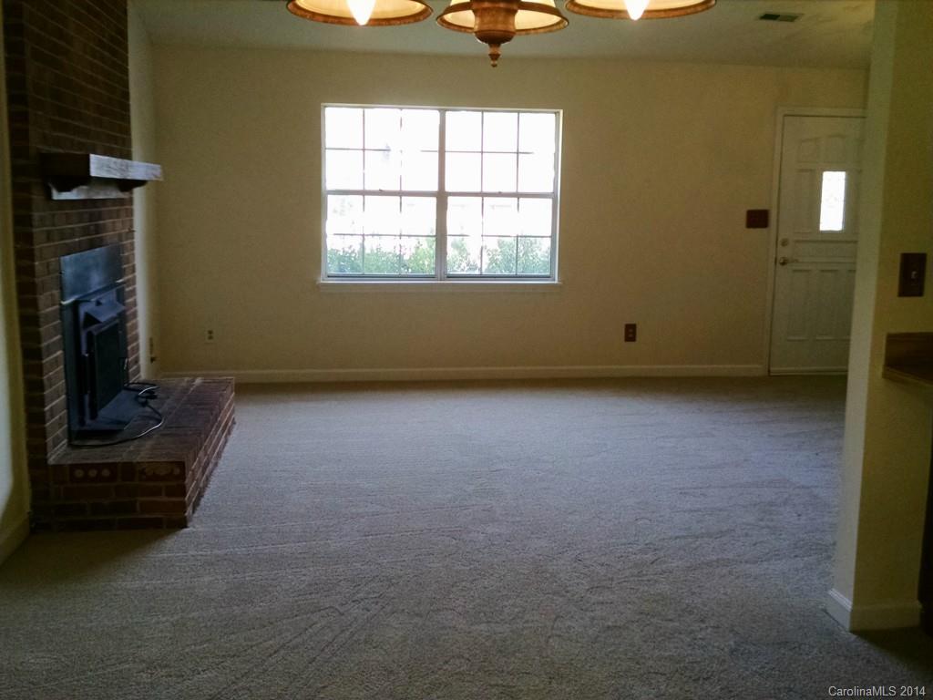 21141 Pine Ridge Drive Cornelius, NC 28031 - Photo 8 of 15 an empty room with a fireplace and windows