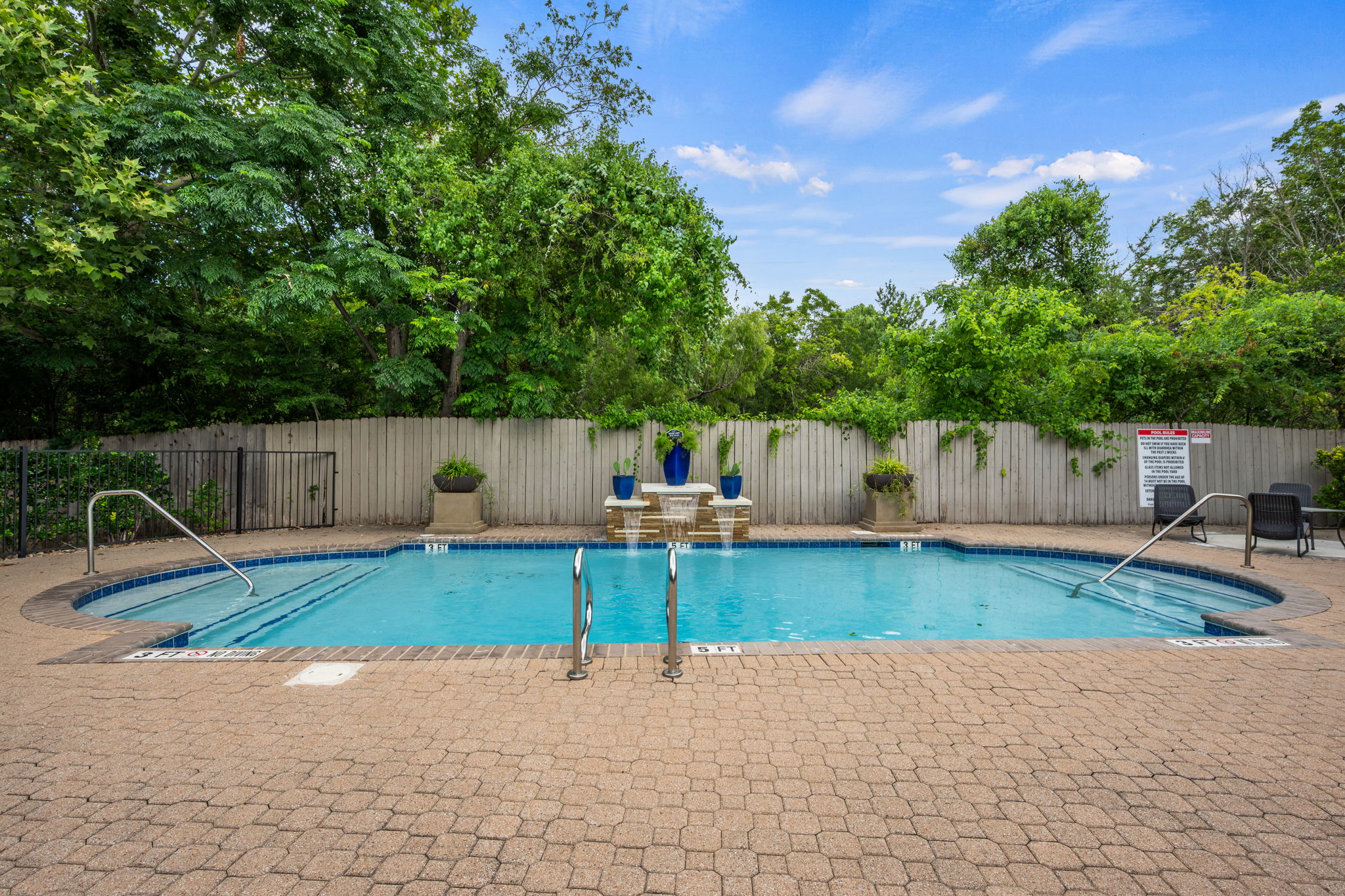 12401 Los Indios Trail, Unit 32 Austin, TX 78729 - Photo 31 of 39 An inviting pool area with a water feature, perfect for relaxation and outdoor enjoyment.