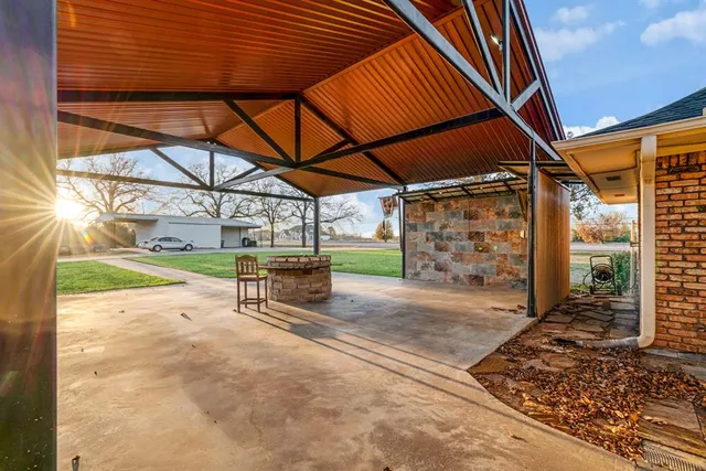 a view of a backyard with table and chairs under an umbrella