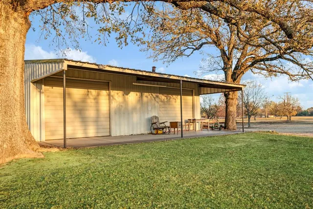 a backyard of a house with table and chairs and floor to ceiling window
