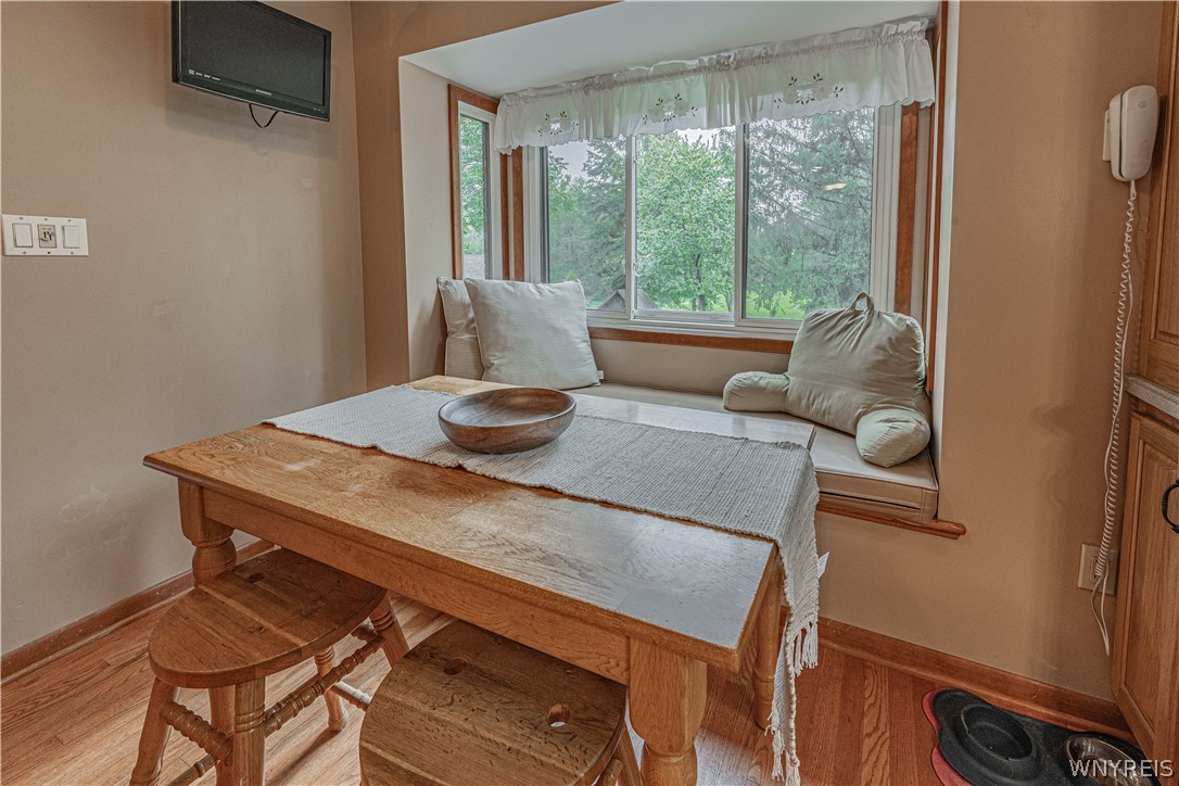 6775 Bear Ridge Road Pendleton, NY 14094 - Photo 8 of 48 Warm hardwood floors complement the wood-framed bay window and built-in bench seating.