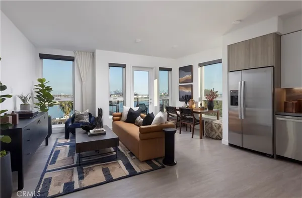 a living room with furniture kitchen view and a refrigerator