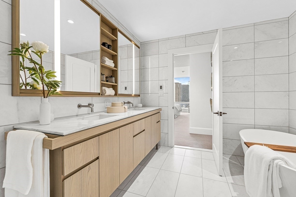 40 Trinity Place, Unit 32A Boston, MA 02116 - Photo 8 of 32 a bathroom with a granite countertop sink a toilet a mirror and shower