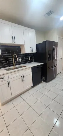 a kitchen with granite countertop a sink and a stove top oven