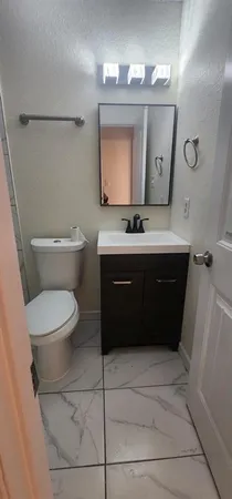 a bathroom with a toilet a sink and mirror
