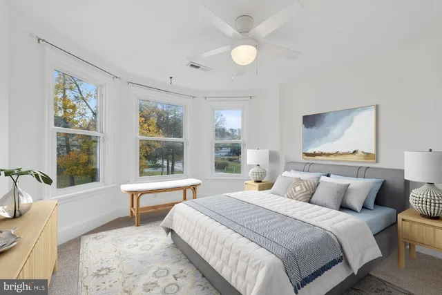 an empty room with windows and fan