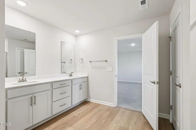 a spacious bathroom with a double vanity sink and a mirror
