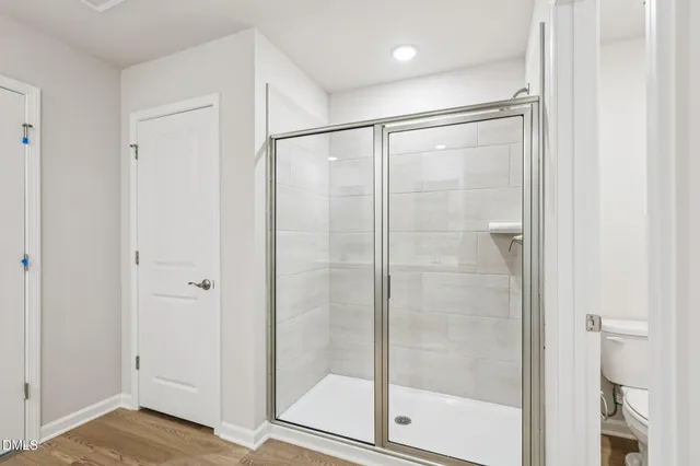 a spacious bathroom with a double vanity sink a mirror and a shower
