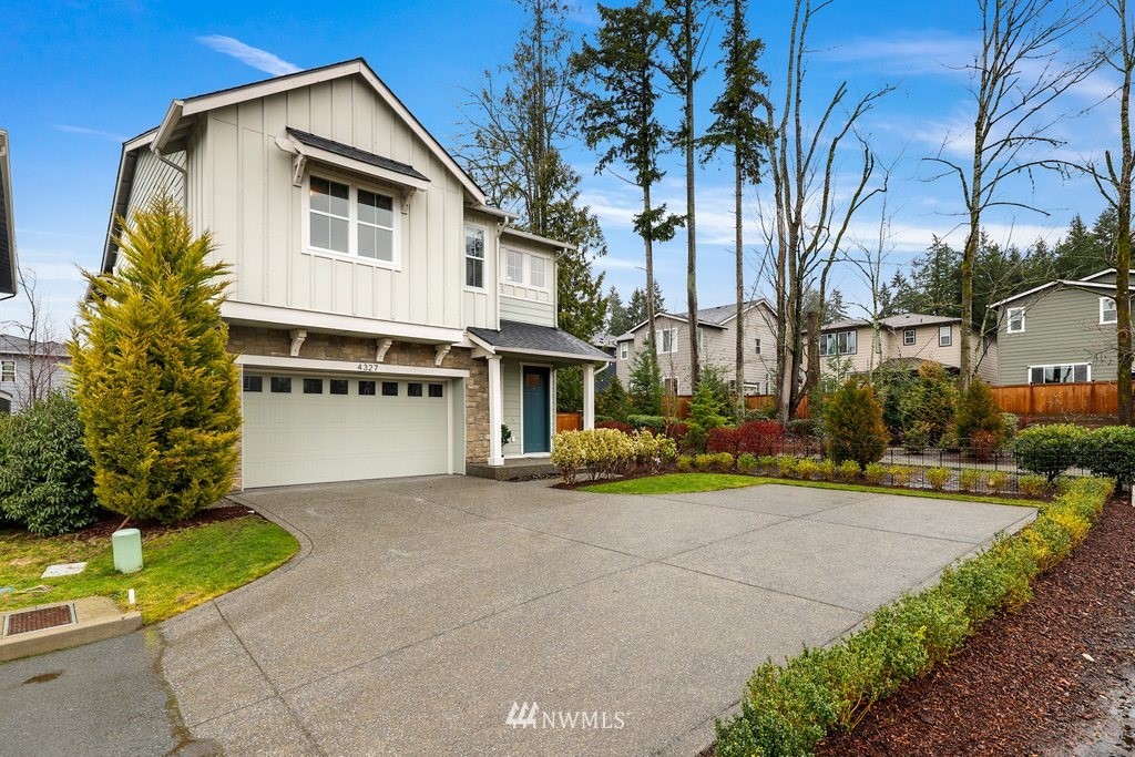4327 223rd Place Southeast Bothell, WA 98021 - Photo 1 of 40 a view of a white house with a large windows and a yard with plants and large trees