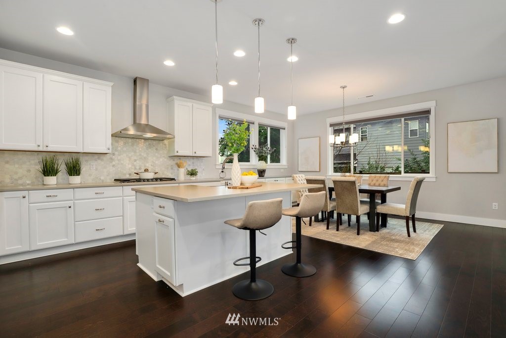 4327 223rd Place Southeast Bothell, WA 98021 - Photo 8 of 40 a kitchen with stainless steel appliances kitchen island granite countertop a stove a sink and a refrigerator with wooden floor