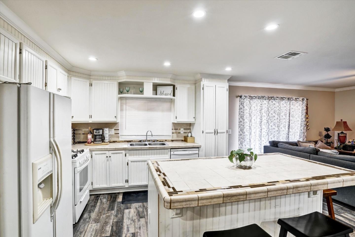15820 South Harlan Road, Unit 22 Lathrop, CA 95330 - Photo 7 of 18 a kitchen with a table chairs refrigerator and cabinets