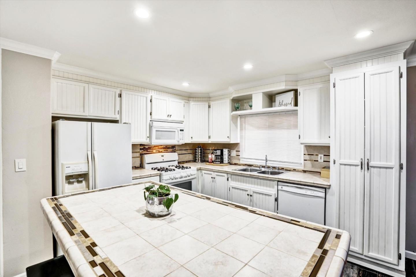 15820 South Harlan Road, Unit 22 Lathrop, CA 95330 - Photo 8 of 18 a kitchen with kitchen island white cabinets and refrigerator