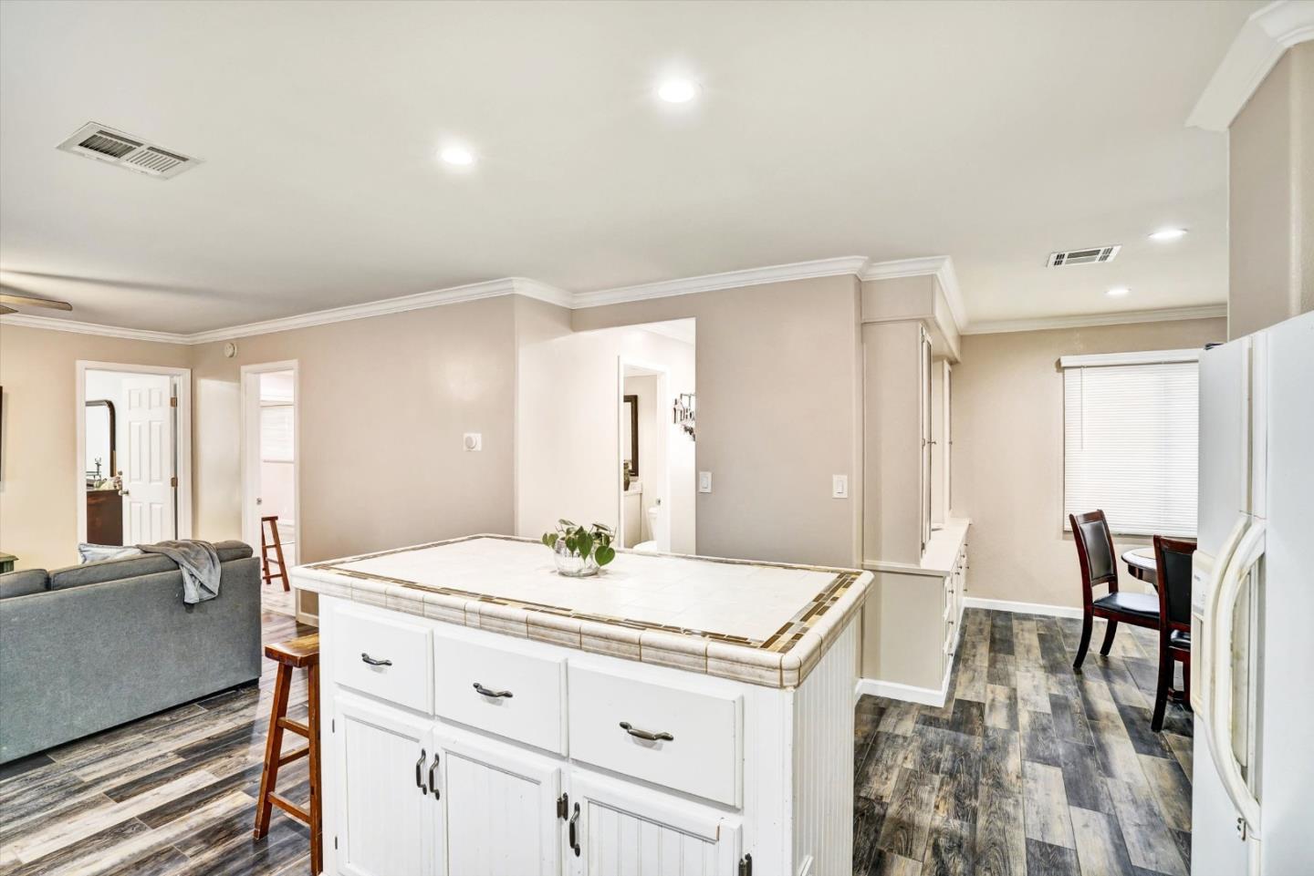 15820 South Harlan Road, Unit 22 Lathrop, CA 95330 - Photo 9 of 18 a living room with stainless steel appliances kitchen island granite countertop a table chairs and a refrigerator