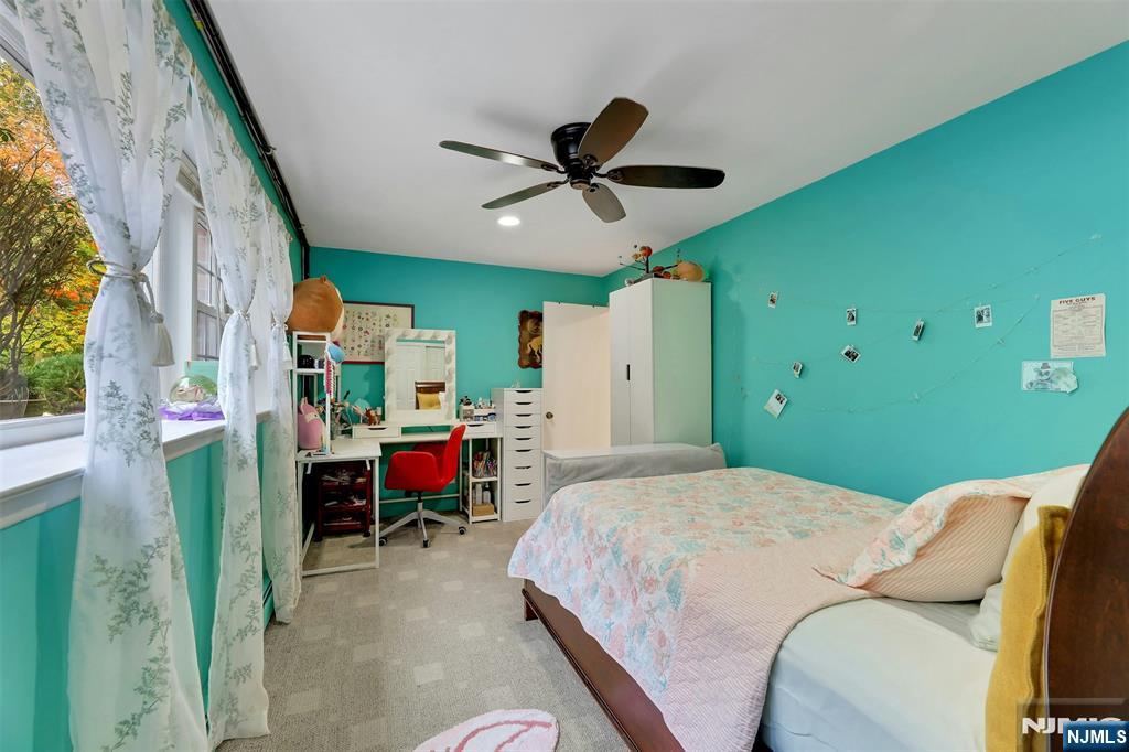 1093 Sheridan Street New Milford, NJ 07646 - Photo 24 of 45 a bedroom with a bed and a chandelier