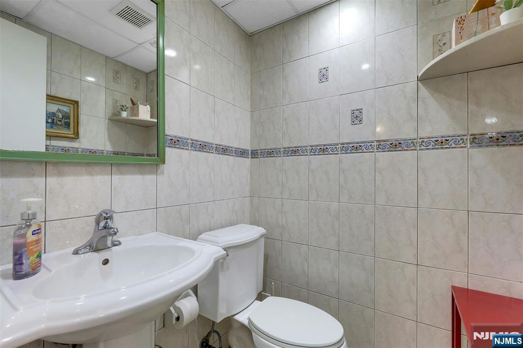 1093 Sheridan Street New Milford, NJ 07646 - Photo 25 of 45 a bathroom with a sink toilet and a mirror