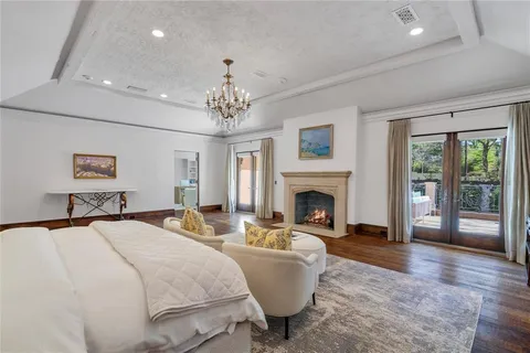 a living room with a large window and a chandelier