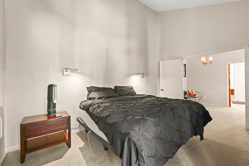 18040 Midway Road, Unit 225 Dallas, TX 75287 - Photo 6 of 24 a bedroom with a bed and a lamp on table
