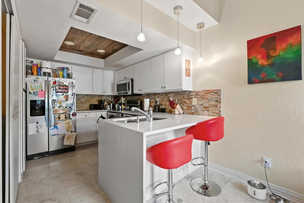 18040 Midway Road, Unit 225 Dallas, TX 75287 - Photo 6 of 24 a kitchen that has a lot of cabinets and refrigerator