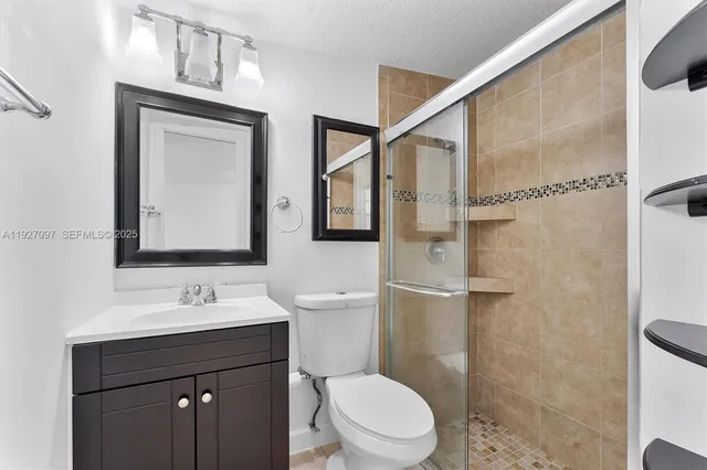 a bathroom with a toilet a sink a mirror and a shower