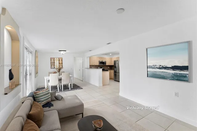 a living room with furniture and view of kitchen