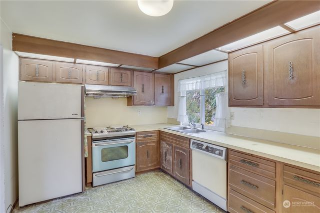a kitchen with a sink cabinets stainless steel appliances and a window