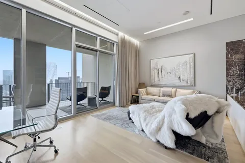 a bedroom with a bed and large windows