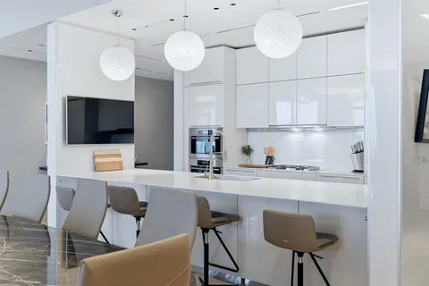 a kitchen with stainless steel appliances a stove a sink cabinets and a dining table