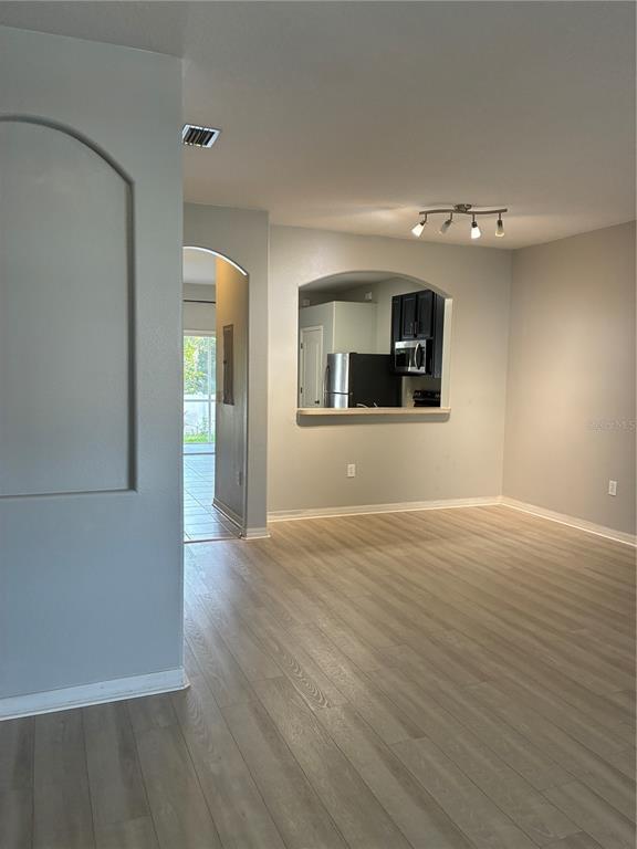 1110 Sleepy Oak Drive Wesley Chapel, FL 33543 - Photo 3 of 35 an empty room with wooden floor and mirror