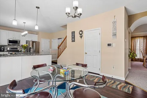 a living room with furniture a rug and kitchen view
