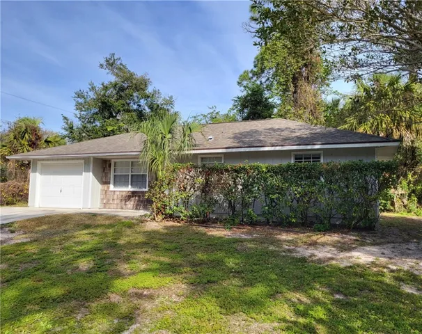 a view of a house with a yard and a garage