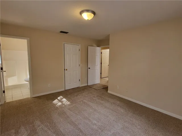 an empty room with yellow space and windows