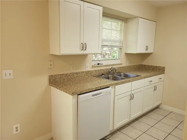 a kitchen with granite countertop white cabinets and sink