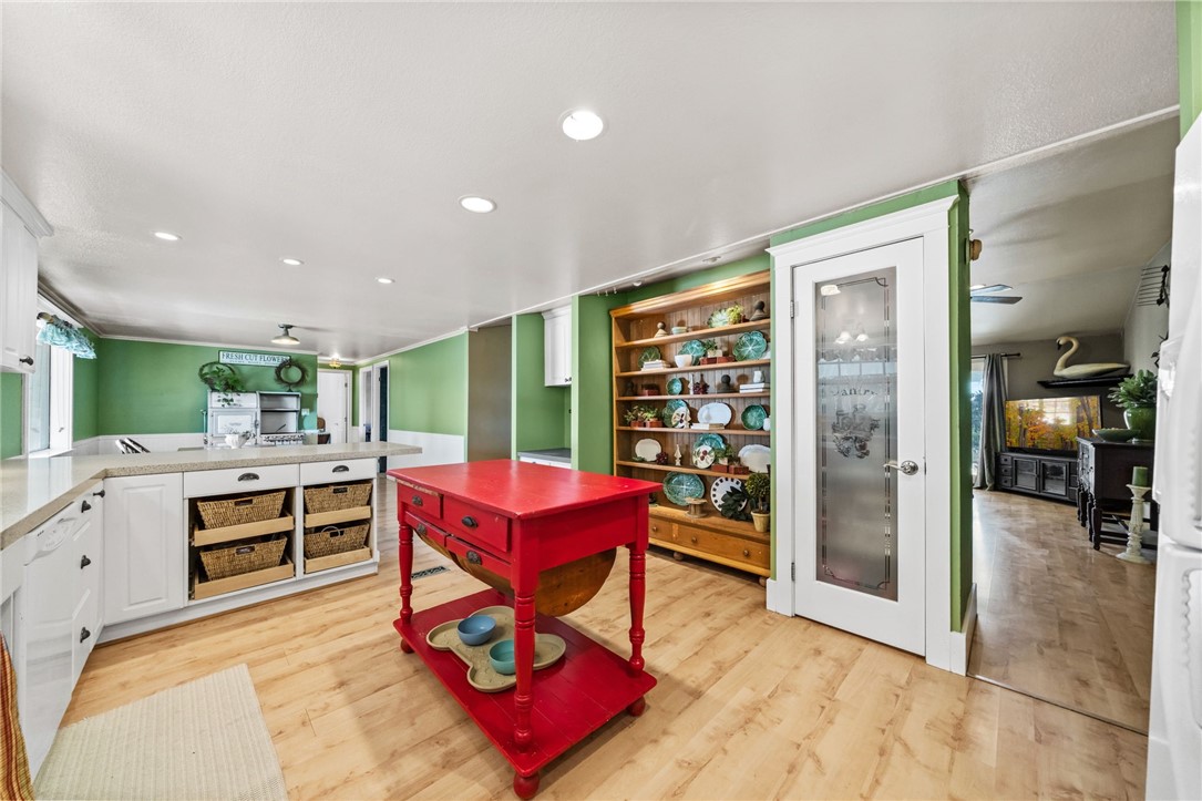 31615 Leon Road Winchester, CA 92596 - Photo 19 of 61 a kitchen with a stove a refrigerator and a dining table with wooden floor