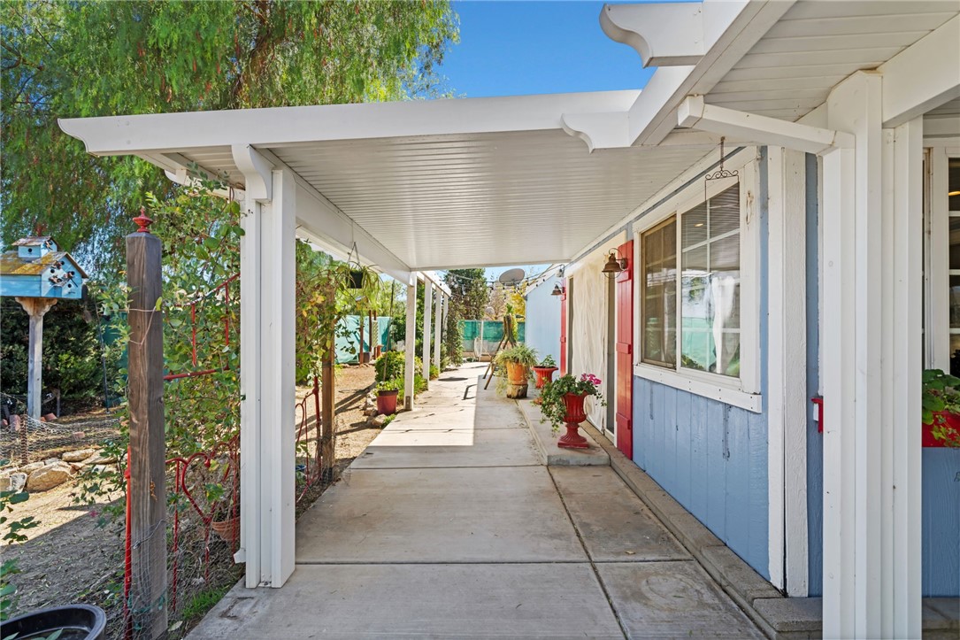 31615 Leon Road Winchester, CA 92596 - Photo 33 of 61 a view of a patio with table and chairs potted plants with floor to ceiling window and wooden floor