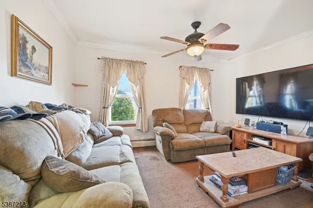 a living room with furniture a chandelier and a flat screen tv