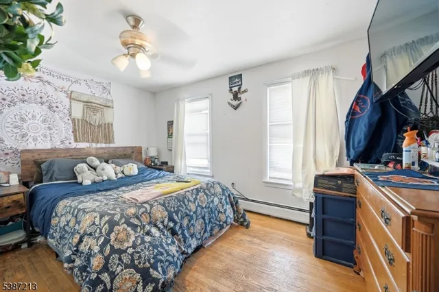 a bedroom with a bed and a flat tv screen on dresser